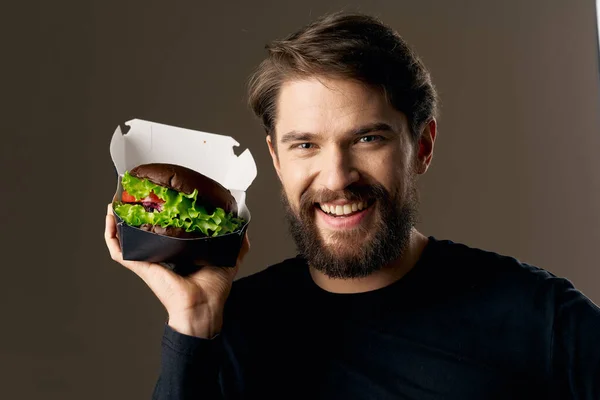 Vousatý muž s hamburgerem fast food strava gurmánská restaurace — Stock fotografie