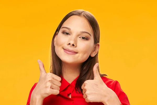 Pretty girl showing thumbs up smile close-up yellow background — Φωτογραφία Αρχείου