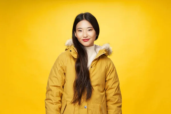 Vrouw in jas winter kleding mode gele achtergrond levensstijl — Stockfoto