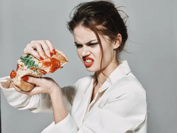 Mulher em hambúrguer em mãos emoções desprazer lanche — Fotografia de Stock