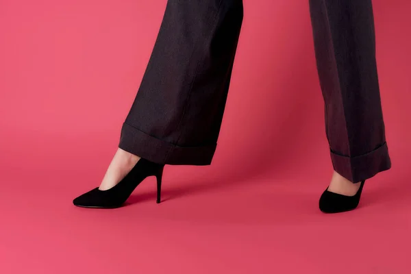 Piernas femeninas en zapatos negros posando fondo rosa estilo moderno — Foto de Stock