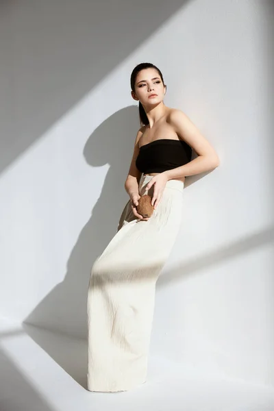 Mooie brunette in een korte top en witte broek poseren — Stockfoto