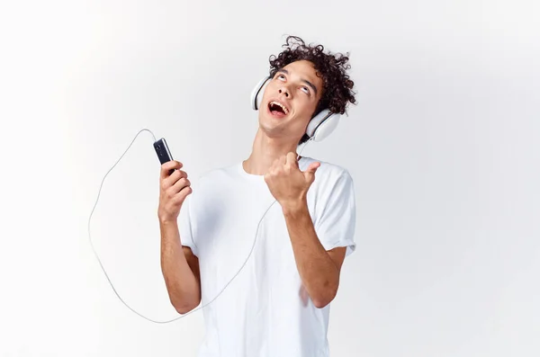 Hombre emocional en camiseta blanca escuchando música con auriculares vista recortada —  Fotos de Stock