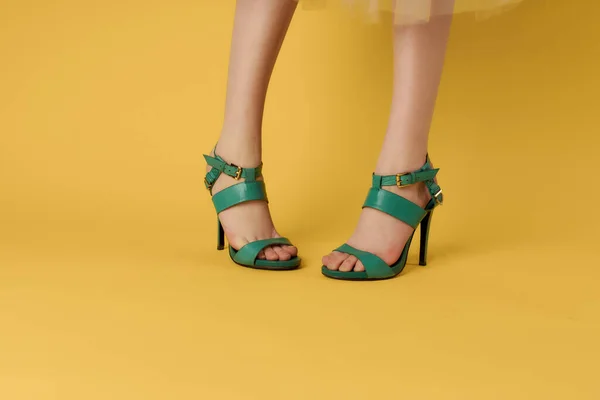 녹색 신발을 신고 다니는 암컷 다리 여름 스타일의 노란 배경 — 스톡 사진