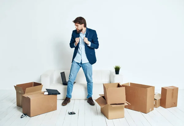 Man zit op de vloer met kartonnen dozen met bewegende dingen werk — Stockfoto