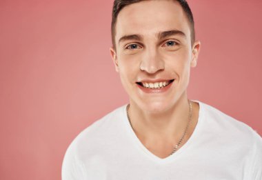 Gülümseyen adam yakın plan beyaz tişört pembe arka plan