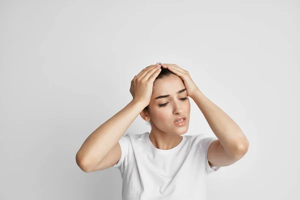 Morena em uma t-shirt branca segurando sua cabeça descontentamento depressão dor — Fotografia de Stock