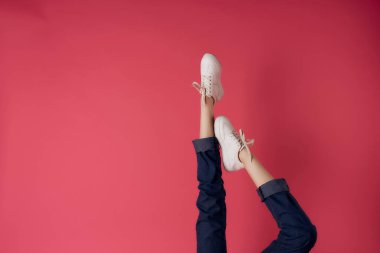 Beyaz spor ayakkabılı kadın bacakları ters görünür pembe arka plan modası