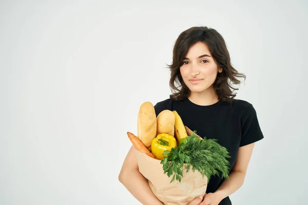 Mujer con un paquete de compras entrega de alimentos a las verduras —  Fotos de Stock