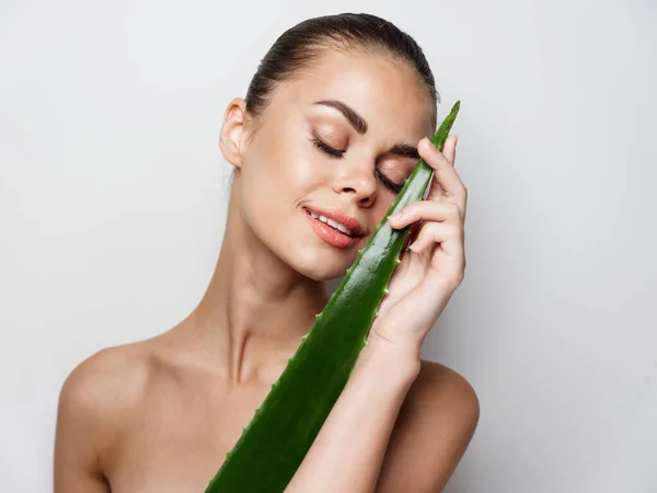 Donna con foglia di aloe spalle nude occhi chiusi sguardo naturale — Foto Stock