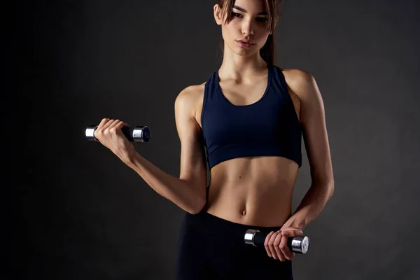 Bonita morena con mancuernas en sus manos figura delgada gimnasio fitness — Foto de Stock