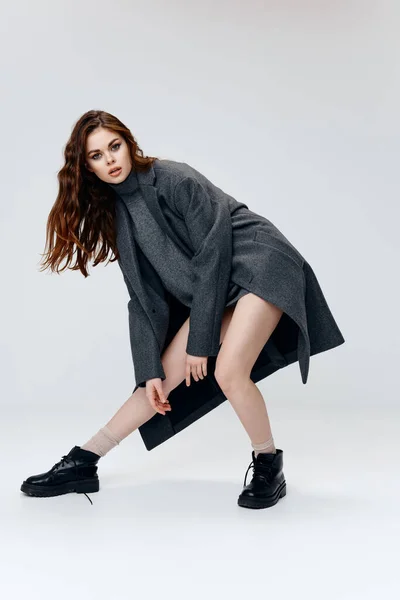 Moda cinza casaco mulher botas luz fundo pose — Fotografia de Stock
