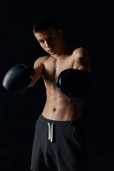 Férfi testépítő felpumpált törzs boksz kesztyű edzés fekete háttér — Stock Fotó