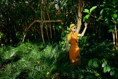 Ormandaki kadın yeşil yapraklar tropik ormanı terk ediyor.