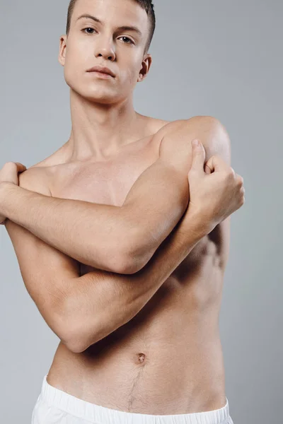Atlétikai férfi megöleli magát a karját pumpált izmok bicepsz testépítő modell — Stock Fotó