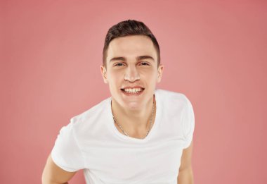 Beyaz tişörtlü gülümseyen adam pembe arka planda yakın plan pembe arka plan duyguları
