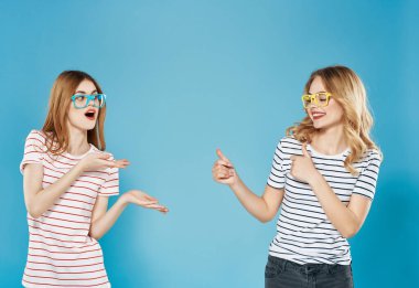 Çizgili tişörtlü iki neşeli kadın yaz stili mavi arka plan