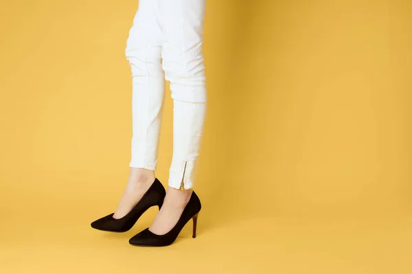 Female inverted legs in black shoes cropped view yellow background — Stock Photo, Image