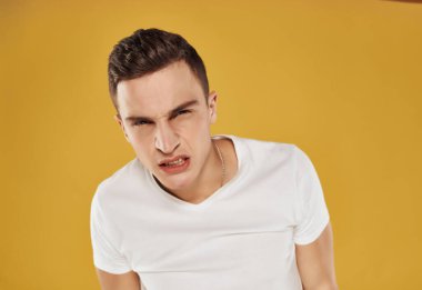 Ciddi ifadesi olan bir adam öfke, hoşnutsuzluk stüdyosu sarı arka plan