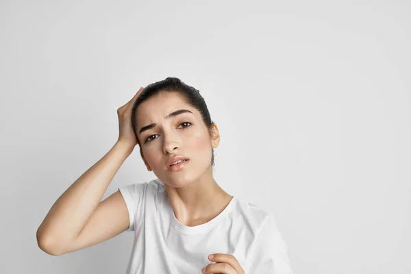 Morena em uma t-shirt branca segurando sua cabeça descontentamento depressão dor — Fotografia de Stock