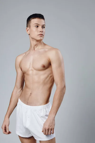 Hombre deportivo con torso muscular en pantalones cortos blancos fondo aislado —  Fotos de Stock