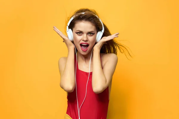 Bonita mujer escuchando música con auriculares divertido fondo amarillo —  Fotos de Stock