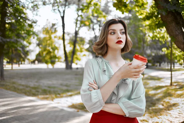 Frau im Freien mit einer Tasse Kaffee auf der Straße — Stockfoto