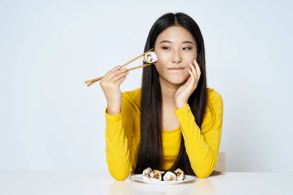 Chica mujer sentado a la mesa palillos dieta comida sushi rollos —  Fotos de Stock