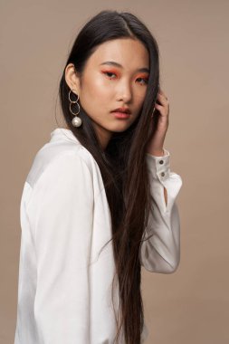 Güzel Asyalı kadın ve orklar makyaj dekorasyonu bej arka plan