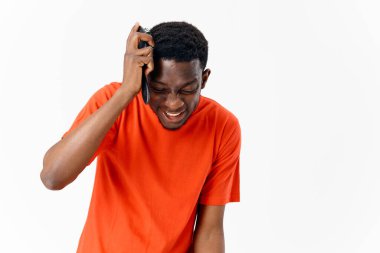 Kapalı gözlü, turuncu tişörtlü Afrikalı Amerikalı.