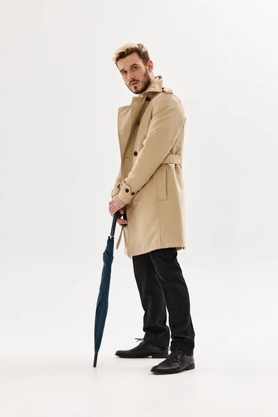 가을 스타일의 베이지 코트를 손에 들고 있는 남자 — 스톡 사진