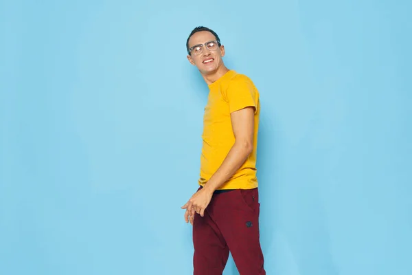 Homme en jaune t-shirt émotions studio fond bleu — Photo