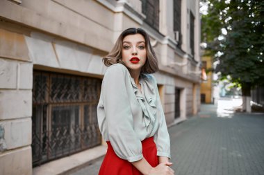 Caddedeki neşeli sarışın. Binanın yanında. Duygusallık var.