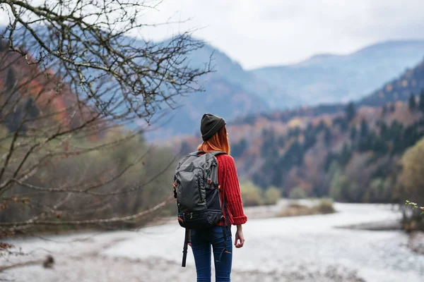Femme heureuse avec sac à dos repos dans les montagnes près de la rivière sur la nature automne paysage air frais — Photo