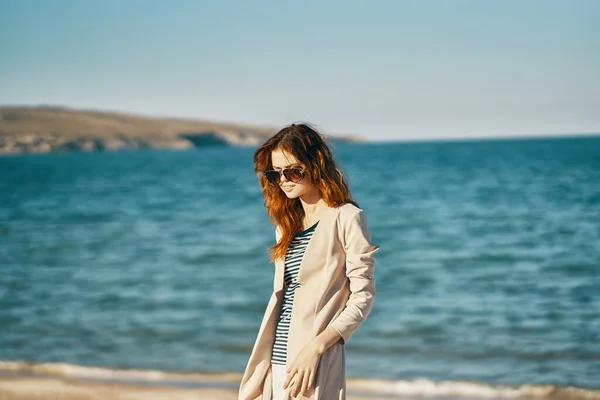 Femme romantique en manteau et t-shirt sur la plage près de la mer dans les montagnes — Photo