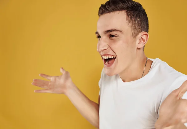 Fröhlicher Mann gestikuliert mit den Händen Emotionen Freude gelber Hintergrund — Stockfoto