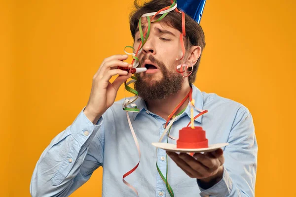 Hombre emocional en una camiseta blanca con una gorra en su cabeza pastel cumpleaños de vacaciones — Foto de Stock