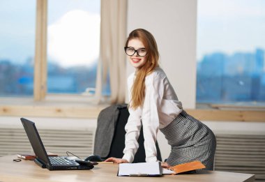 Masaüstü poz ofisinin yanında takım elbiseli kadın sekreter