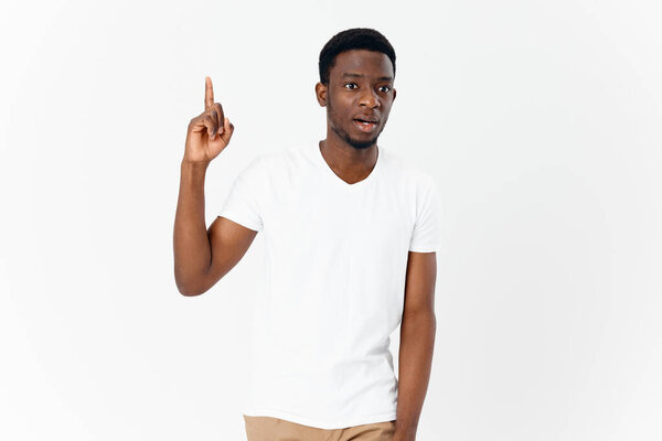 Man of african appearance gesturing with hands in white t-shirt cropped view studio. High quality photo