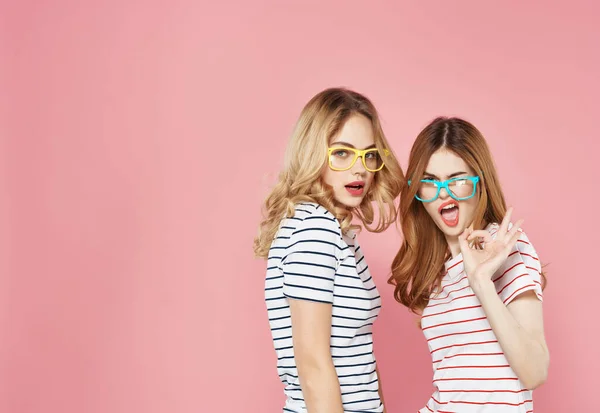 Két aranyos barátnő színes szemüvegben csíkos pólók divat szórakoztató — Stock Fotó