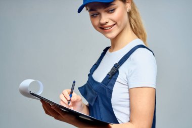 Mavi üniformalı kadın kurye servisinde çalışıyor.
