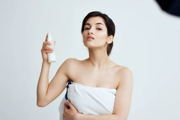 Kvinna med handduk nakna axlar lotion ren hudvård — Stockfoto