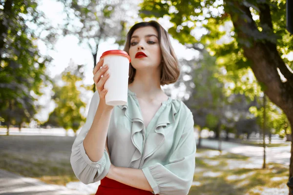 Mujer alegre con una taza de café en el parque por la calle estilo de vida de ocio — Foto de Stock