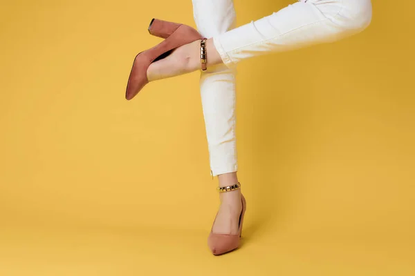 Piedi femminili scarpe moda posa primo piano sfondo giallo — Foto Stock