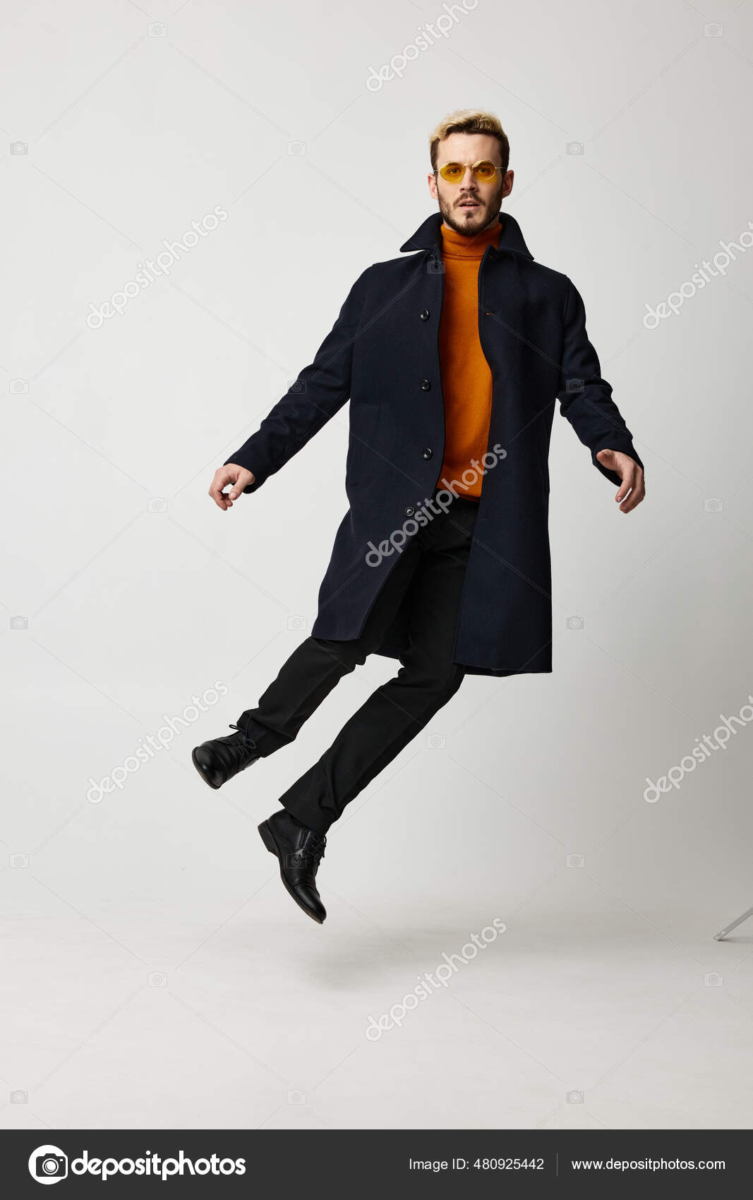 Male model jumped up in a black coat in trousers and boots — Stock
