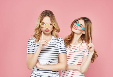 Renkli gözlüklü iki tatlı kız arkadaş. Çizgili tişörtler, moda eğlencesi.