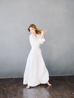 Beyaz elbiseli güzel bir kadın lüks eller hareketi yapıyor.