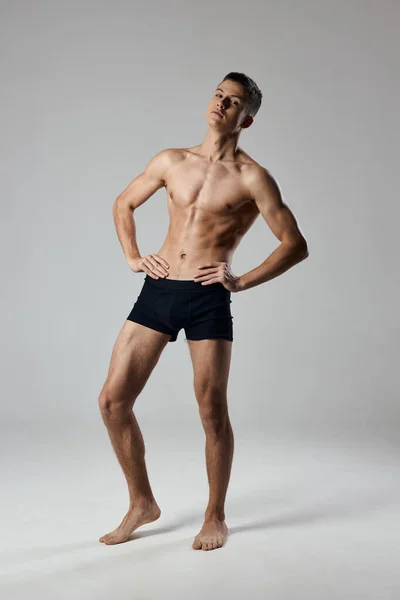 Sexy Athletin hält Hände an einem Gürtel in voller Größe auf grauem Hintergrund Bodybuilder Fitness — Stockfoto