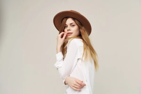 身穿白衬衫、头戴帽子的女人，穿着现代风格的衣服，呈现出迷人的孤独寂寞的背景 — 图库照片