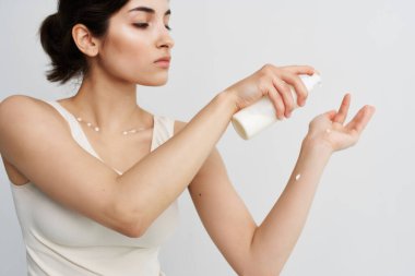 Beyaz tişörtlü güzel kadın kozmetik cilt bakımı arka planında